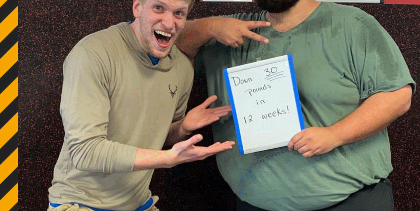 Doug Volker posing with a client. The client holds a sign that says, "Down 30 pounds in 12 weeks!"